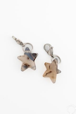 Silver-tone star charm with translucent beige stone, hinged clasp