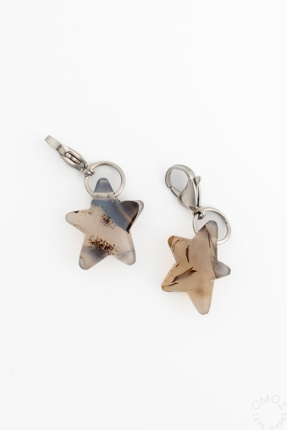 Silver-tone star charm with translucent beige stone, hinged clasp