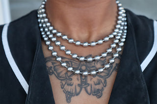 Layered silver-tone ball chain necklace with round metal beads on close neckline