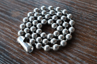 Silver-tone ball chain necklace close-up with round beads and curved clasp