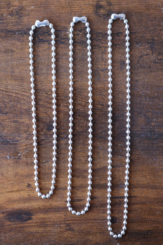 Small silver ball chain necklace, three strands displayed side by side