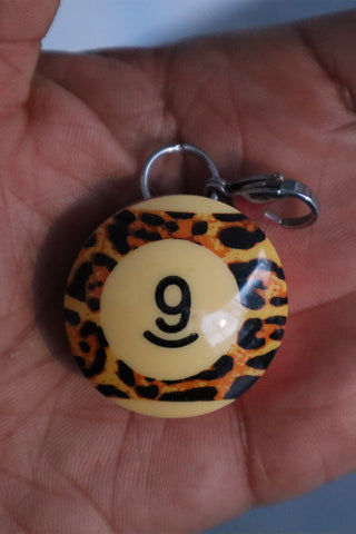Round leopard-print pool charm with number 9 smiley face and metal clasp ring