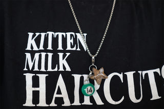 Necklace with a pendant and a green #14 pool ball charm on a black shirt with white text.