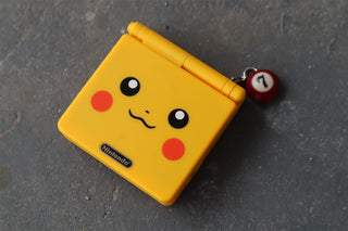 Mini pool charm with red-and-white number 1 bead on yellow Nintendo card case