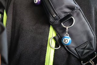 Black bag strap with #10 blue pool ball keychain attached 