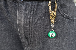 Mini pool charm with green round bead labeled 6 on black jeans