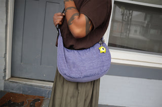 Purple crossbody bag with silver star-maille chain and lime charm on strap
