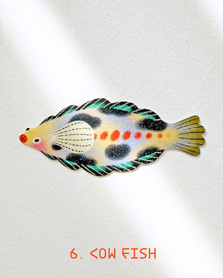 Glitter Cow fish sticker with teal, black, and gold scales