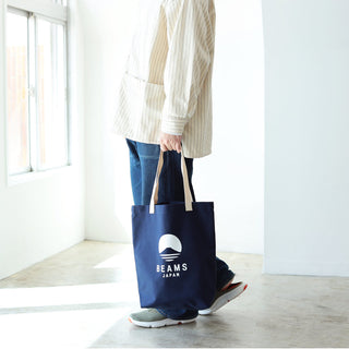 Indigo tote bag with BEAMS JAPAN logo, carried by long fabric handles