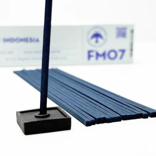 Single incense stick in square holder with stacked Bali Rain incense sticks