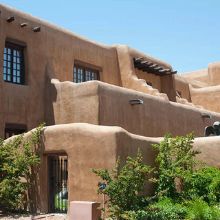 Santa Fe style stucco building facade with arched windows and roofline.