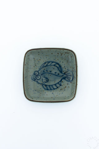 Square ceramic dish with rounded edges, teal glaze and blue flounder fish design