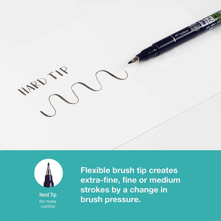 Dark blue brush pen tip making calligraphy lettering on white paper