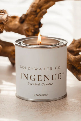 GOLD+WATER CO. INGENUE scented candle in silver metal tin with lit wick