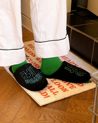 Black rest room shoes with neon heel text and blue/green pair colors, worn with robe
