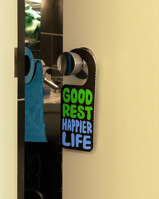 Neon-letter rest room shoes hanging on a door hook, black with multicolor “Good Rest” text