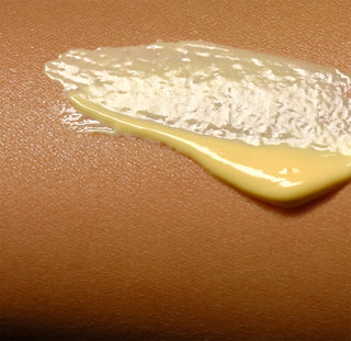 Thick yellow sunscreen cream swatch spread on skin
