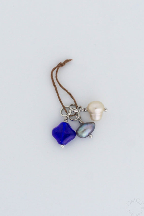 3-piece charm set with blue and pearl pendants on brown cord