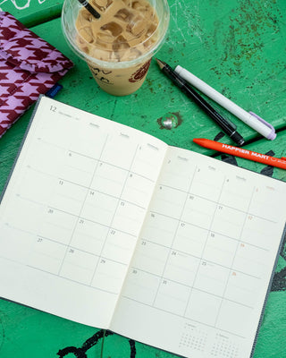 A5 monthly planner, gray, open to calendar spread with monthly grid