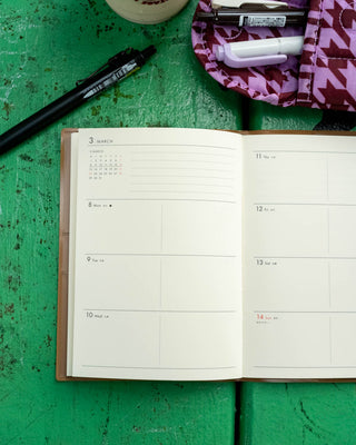 A6 weekly block planner open to dated weekly pages with grid lines