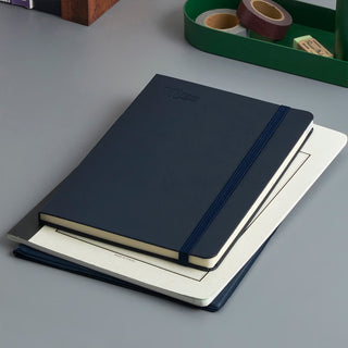Navy A5 weekly planner with blue elastic band, closed front and visible page edges