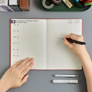 Opened weekly planning planner with lined calendar grid and red borders for writing