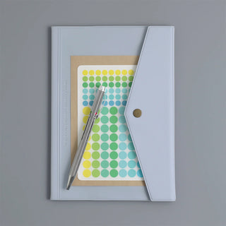 Light blue A5 monthly planner with card insert, pen, and dot sticker sheet