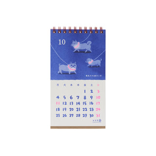 Blue retro desk calendar with cat illustration, month 10 date grid
