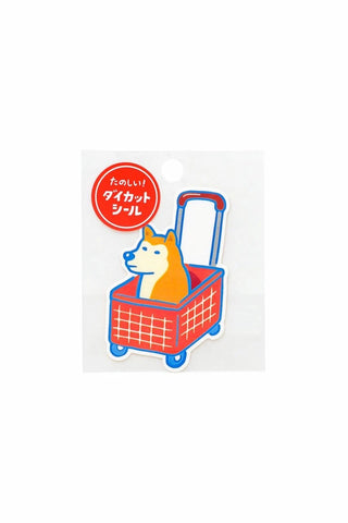 Die-cut dog sticker: orange dog in a red grid shopping basket