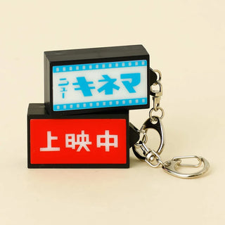 Light-up retro keychain sign with red cinema text, black housing and metal keyring