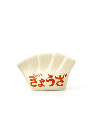 Porcelain dumpling pen holder, cream white with red Japanese characters, close front view