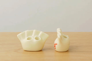 Porcelain dumpling pen holder, cream white with red Japanese characters, front and side view