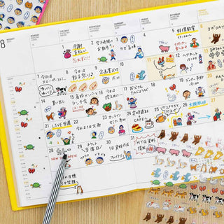 Open planner calendar with human character stickers and small icon accents on dates