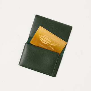 Green leather card case with yellow globe logo patch on front