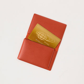 Orange card case with foldover design and gold BEAMS graphic patch