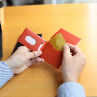 Red and orange leather card cases with card slots and printed logos