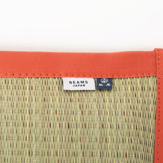 Orange woven cushion corner with border and BEAMS JAPAN tag label on the cushion