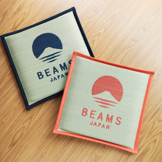 Two BEAMS JAPAN logo cushions: navy border and orange border on light fabric
