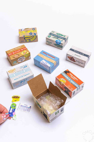 Sticker seal box open with clear wrap and stickers; several theme boxes shown