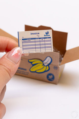 Hand peeling a Banana seal sticker from a Banana sticker box