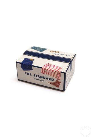 “The Standard” seal sticker box with blue-and-white front and red stripes