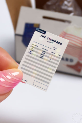 “The Standard” sticker sheet card held in hand with a multicolor bar chart