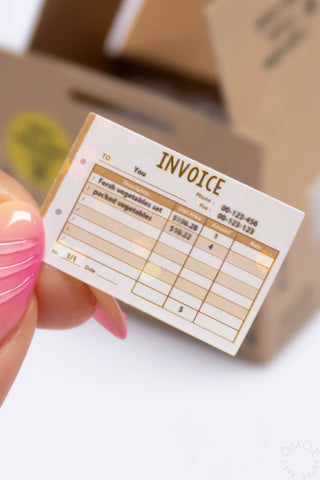 Invoice seal sticker card held in hand with printed grid and “INVIOCE” heading
