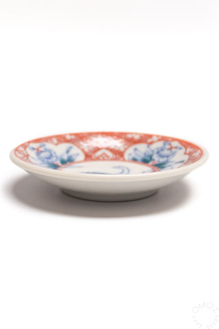 Porcelain mini plate side view with red and blue dinosaur motif around rim