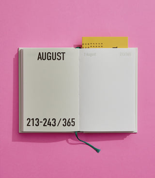 Open light-grey diary notebook showing “AUGUST” and date range “213-243/365”.