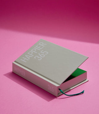 Light-grey diary notebook cover with “Happier 365” text and green elastic tie.