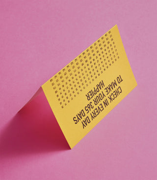 Yellow insert card with small date grid and angled text “Happier 365 days”.