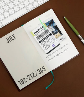 Open 365 diary notebook page marked JULY with printed details and green bookmark