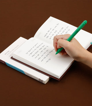 Diary notebook open with handwritten notes, green pen writing on printed pages