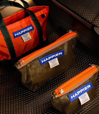 Set of mesh layer pouches on organizer, showing HAPPIER labels and orange zippers